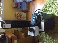 Image showing two Honeywell tower fans, one Ativa paper shredder and the Intex Quick-Fill Electric Pump box on a green rug and wooden floor.