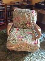 Front view of wooden armchair with floral cushions