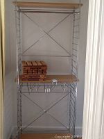Full view of the metal and wood clothes rack showing frame and wooden shelves with stacked cedar racks on top shelf