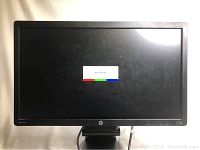 Front view of HP 24 inch monitor showing screen with a test color equalizer image and black bezel.