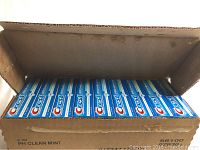 Open box showing multiple Crest toothpaste tubes arranged inside.