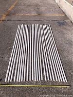 Array of 24 white primed MDF shoe molding strips laid out on the ground, showing quantity and uniformity.
