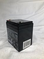 Black rectangular rechargeable sealed lead acid battery with label showing battery specifications and barcode on side, photographed from the side.