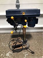 Full view of the Mastercraft 8 inch drill press showing motor housing, yellow control handles, column, and base.