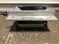 Front view of 7 inch bench top tile saw showing the cutting surface, adjustable cutting fence, and water basin below.