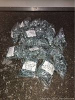 Bags containing a large quantity of small, silver-colored wood screws with labels indicating 1 1/2 inch size.
