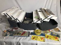 Wide shot of open Kangaroo tacklebox showing all white compartment trays extended with various fishing accessories arranged in front.