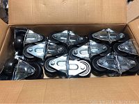 Top view showing all 12 hard rubber casters neatly arranged inside a cardboard box.