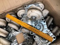 Boxed set of 12 nylon castor wheels showing size comparison with a ruler and condition of wheels and metal plates.
