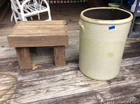 Photo of a large glazed clay crock and a wooden table on a wooden deck, showing overall condition and scale.