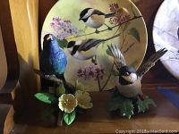 Photo showing two Lenox porcelain bird figurines and a decorative plate behind them.