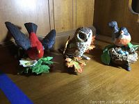 Front view showing Scarlet Tanager, Saw Whet Owl, and American Robin porcelain birds arranged on wooden shelf.