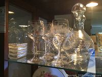 Full view showing decanter with stopper, multiple wine glasses, small serving dish, and other glassware