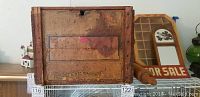 Closed vintage wooden coffee roasters box showing front and one side with rolling pin underneath.