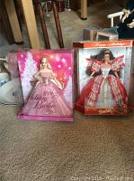 Two boxed Barbie dolls: 2009 Holiday Barbie in pink gown and 10th Anniversary Happy Holidays Barbie in red and white gown.