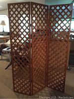 Front view of the wood lattice room divider showing all three connected panels in an open position