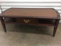 Front view of the wooden coffee table showing the tabletop and tapered legs.