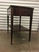 Front and side view of the small wooden table, showing drawer and lower shelf.