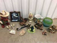 Lot of assorted animal figurines and decorative items including armadillo, birds, sea shells, floral egg, parrots mug, frog, bears, mice, and fish candle holder.