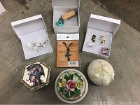 Photo of various jewelry items laid out including necklaces, earrings, bracelet, and jewelry boxes