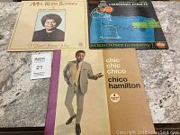 Four vintage vinyl records laid out on a surface, showing album covers for Chico Hamilton, Katie Sankey, Julian Cannonball Adderley.