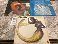 Photo showing all three vinyl record album covers on a table: "Dynamic!" by Dakota Staton, "The Sonic Man" by Jerry Butler, and "Fillet of Soul" by Isaac Hayes with mermaid artwork.