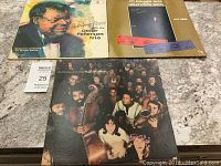 Three vintage jazz vinyl records displayed on a tabletop: Hugh Masekela, Oscar Peterson Trio Swinging Brass, and CTI Summer Jazz Hollywood Bowl Live 1983.