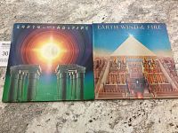 Photo showing both Earth, Wind and Fire vinyl records: I Am (1979) and All 'N All (1977) with their original album covers on a granite surface.