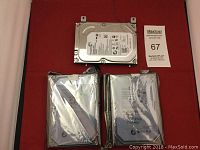 Three Seagate internal hard drives, two wrapped in anti-static bags, one unpacked with visible label showing model and Seagate branding.