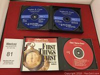 Photo showing two open CD cases containing three CDs by Stephen R. Covey, including 'The 4 Disciplines of Execution' and 'First Things First' titles, plus a MaxSold auction card.