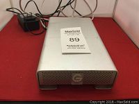 Front view of silver G-Technology G-Drive with perforated front panel and logo visible.