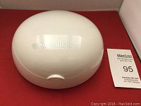 Closed white rounded case with NuBrilliance logo on top.