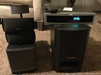 Overall view of components: three satellite speakers stacked on left, subwoofer and receiver on right