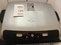 View of the George Foreman grill with digital display showing 5 minutes timer and power on.