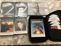 Six sets of Tony Robbins motivational audio CDs with cases and discs arranged on a floor showing titles and cover images.
