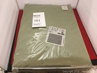 Full view of the packaged greenish full sheet set with auction tags