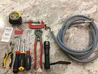Full tool set including measuring tape, screwdrivers, pliers, wire cutters, flashlight, hose, C-clamp, and hex keys.