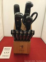 Full view of J A Henckels International knife set in wooden block with multiple knives and scissors, paring knife missing.