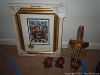 Framed artist proof print signed by Emmet Kelly featuring clown portrait, two wood bust carvings, and brass mortar and pestle.