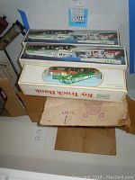 Photo showing Hess Toy Truck Bank box and two Hess tanker truck boxes stacked, including detailed packaging designs.