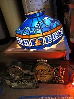 Front view showing the stained glass Busch hanging lamp suspended above two beer signs