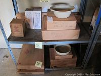 Shelves with various Pampered Chef boxes containing baking bowls, bread crock, and bread tubes