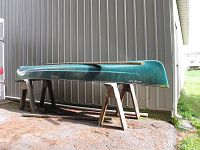 Side view of green Old Town Guide 147 canoe on sawhorses