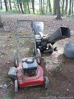 Both Yard Machines chipper and Murray mower in outdoor setting, front view