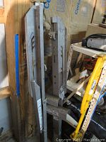 Metal scaffolding support brackets with adjustment features and some wear.