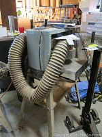 Side view of planer mounted on stand with dust hose attached
