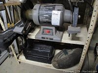 Front and side views of the Craftsman 8-in bench grinder showing the grinding wheels, motor housing, power switch, and wheel supports.