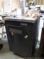 Full view of black cabinet beer dispenser with stainless top, drain tray and draft tower