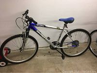 Full side view of the Victory Dyno mountain bike showing silver and blue frame, knobby tires, and blue padded saddle.