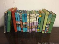 Photo of vintage children's books including Hardy Boys and Bobbsey Twins books arranged on a shelf, showing colorful book spines.